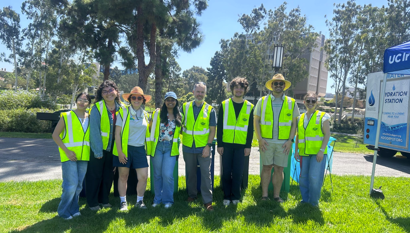 UC Irvine Sustainability staff and student volunteers in safety vests at the Staff Appreciation Picnic, standing beside the H2O Depot mobile hydration station